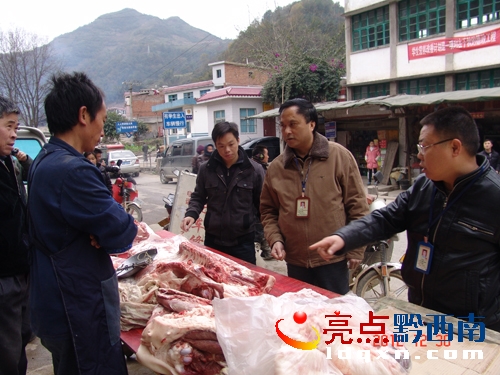 執(zhí)法人員對經營豬肉的攤位進行認真檢查.JPG