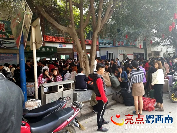 望謨車(chē)站站前街邊人行道占滿(mǎn)了旅客.jpg